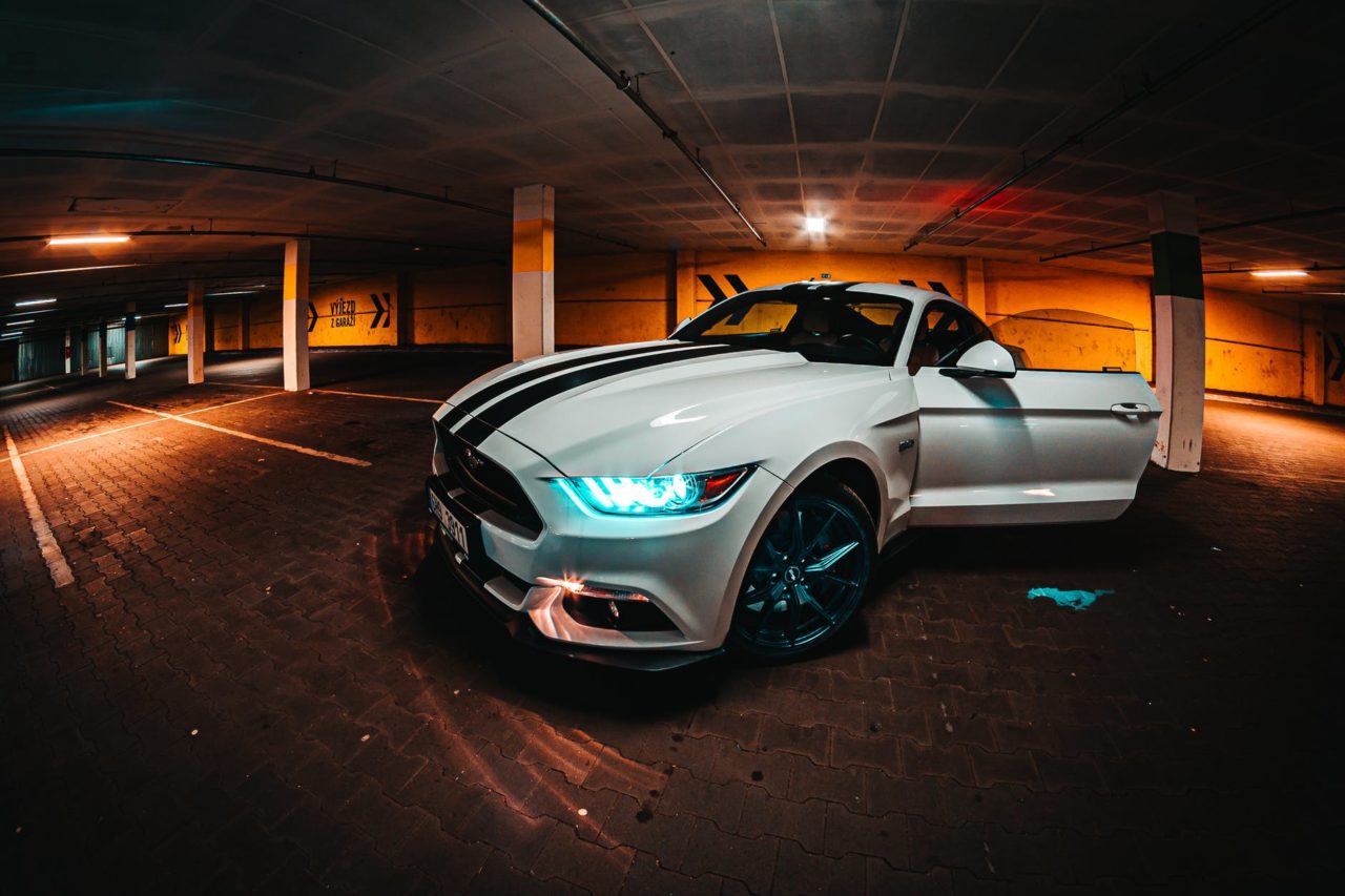 parked white coupe inside parking lot